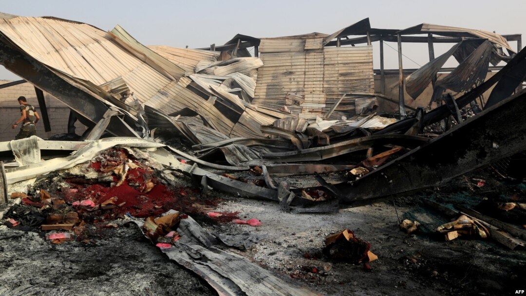 FILE - Yemeni men inspect the damage at a factory allegedly targeted by Saudi-led coalition's airstrikes in the Red Sea town of Hodeida, July 27, 2018.