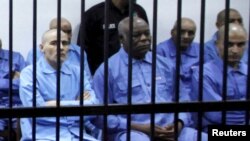 Abu Agila Mohammad Mas'ud Kheir Al-Marimi sits behind bars during a hearing at a courtroom in Tripoli