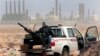 FILE - In this March 5, 2011 file photo, an anti-government rebel sits with an anti-aircraft weapon in front an oil refinery, after the capture of the oil town of Ras Lanouf, eastern Libya. The official Libyan news agency said Sunday, April 6, 2014 that t