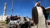 A Palestinian stands near a burnt car in the West Bank village of Kusra, near Nablus, February 21, 2013.