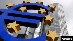 A euro logo sculpture is seen in front the headquarters of the European Central Bank in Frankfurt October 26, 2014.