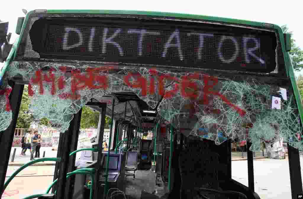 People observe a destroyed urban bus with a destination sign that reads ''This bus goes to Dictator'' at Taksim Square, Istanbul, June 6, 2013.