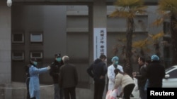 지난 20일 중국 후베이성 우한의 병원에서 의료 관계자가 환자의 가족들의 방문을 제한시키고 있다. 
