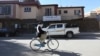 FILE - An Afghan man rides his bicycle in front of the office of the Agency Coordinating Body for Afghan Relief (ACBAR) in Kabul, Afghanistan, Nov. 6, 2016. Criminal gangs in Afghanistan often kidnap foreign aid workers, sometimes selling them to insurgents.