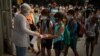 FILE - Students wearing face masks to prevent the spread of coronavirus disinfect their hands before entering their school in Barcelona, Spain, September 14, 2020. 