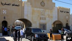 In this June 21, 2021 file photo, Bassem Awadallah, a former royal adviser, leaves a state security court in a vehicle after the first session of his closed-door trial, in Amman, Jordan. 