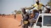 Refugees who fled the recent violence in South Sudan and crossed the border into Uganda arrive and await transportation from a transit center in the town of Koboko, Uganda, to a nearby settlement in Arua District, in northern Uganda Monday, Jan. 6, 2014. 