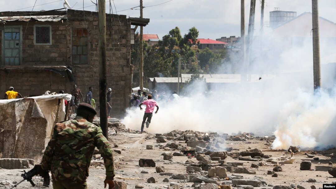 A riot policeman disperses residents during a clash over the demolition of homes at the Mukuru Kwa Njenga informal settlements to pave way for construction of the Nairobi Expressway with Industrial Area in Nairobi, Dec. 27, 2021.