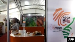 FILE - A woman looks on behind a stand during the 18th African Growth and Opportunity Act (AGOA) forum, in Abidjan, Ivory Coast, Aug. 5, 2019. 