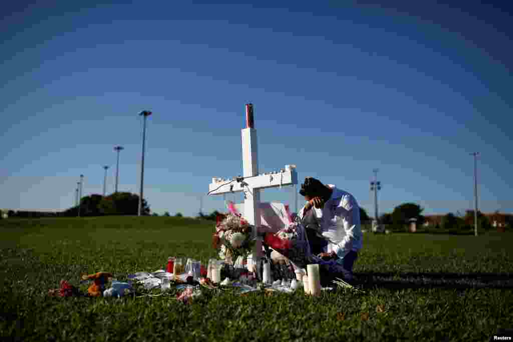 Joe Zevuloni mourns in front of a cross placed in a park to commemorate the victims of the shooting at Marjory Stoneman Douglas High School, in Parkland, Florida, U.S.