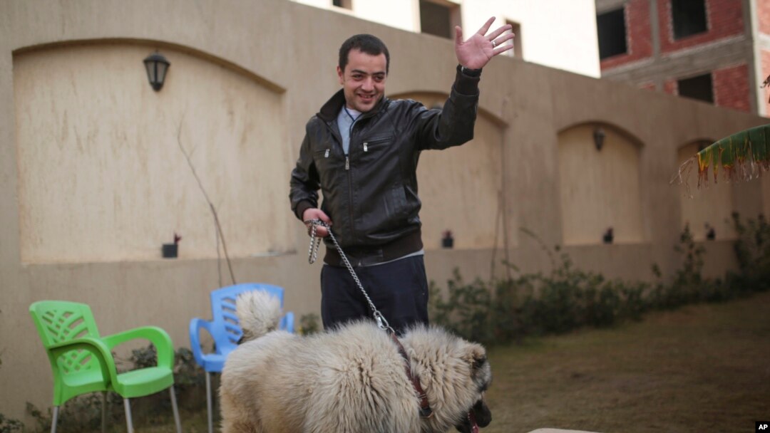 FILE - Baher Mohamed, an Al-Jazeera journalist recently released, waves at his children at his home in 6 October city, a suburb southwest of Cairo, Egypt, Feb. 14, 2015.