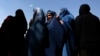 Afghan women line up to receive aid from the Afghan government in Kabul on August 1, 2013. 