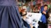 A woman reads a local newspaper displaying a photo of U.S. President Donald Trump on its front in Kabul, Afghanistan, Aug. 22, 2017. 