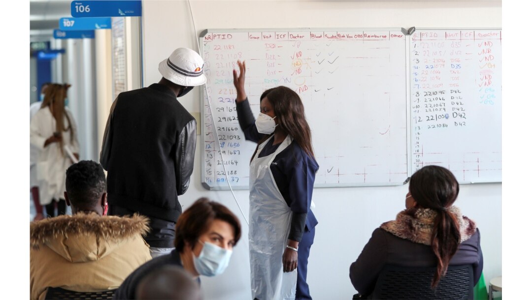 FILE - A health worker talks to a vaccine trials' volunteer in Johannesburg, South Africa, August 27, 2020. (REUTERS/Siphiwe Sibeko)