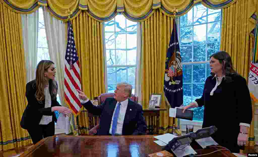 U.S. President Donald Trump confers with White House Communications Director Hope Hicks (L) as White House Press Secretary Sarah Sanders (R) listens during an interview with Reuters at the White House in Washington, Jan. 17, 2018.