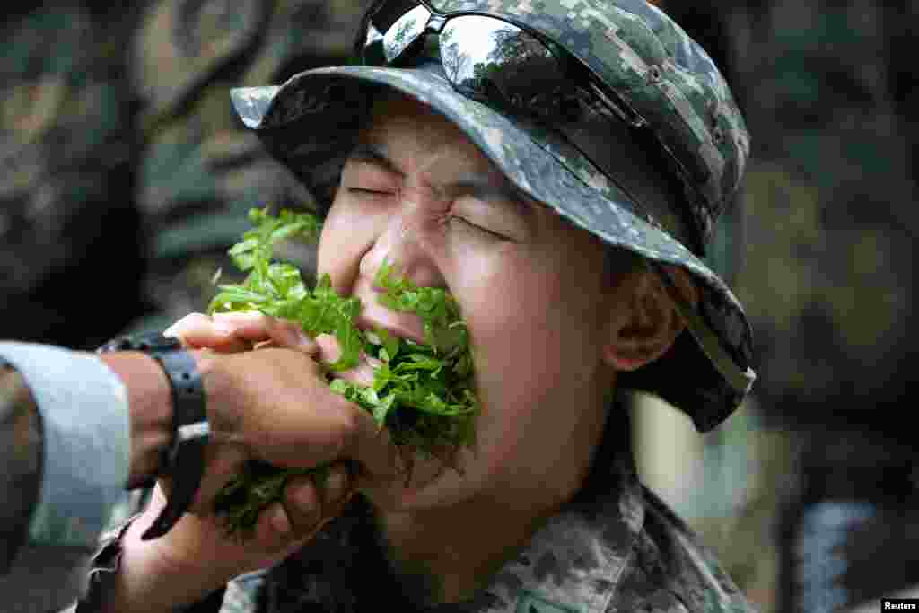 A South Korea marine eats local vegetables during a jungle survival exercise as part of the "Cobra Gold 2018" (CG18) joint military exercise, at a military base in Chonburi province, Thailand.