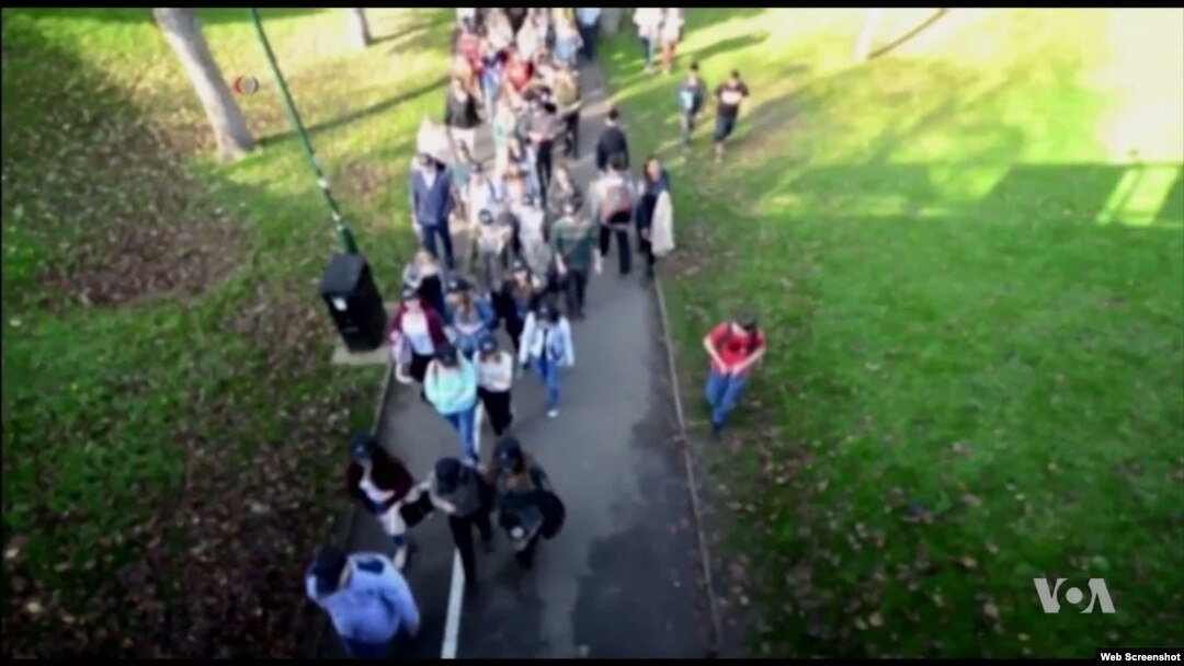 Undergraduate students that share a group identity, walk to a library square on the Sussex campus, while researchers film the event to observe that behavior