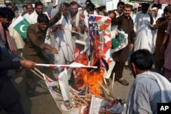 FILE - Pakistani protesters burn posters of U. S. President Donald Trump in Peshawar, Pakistan, Aug. 30, 2017. Protesters have objected to Trump's allegation that Islamabad is harboring militants who battle U.S. forces in Afghanistan.
