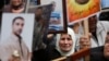 Palestinians hold pictures of jailed relatives during a protest marking "Palestinian Prisoners Day," West Bank city of Ramallah, April 17, 2013.