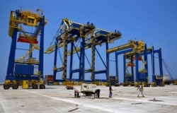 This Aug. 9, 2017 photo shows construction workers in the port of the northern city of Tripoli, Lebanon.