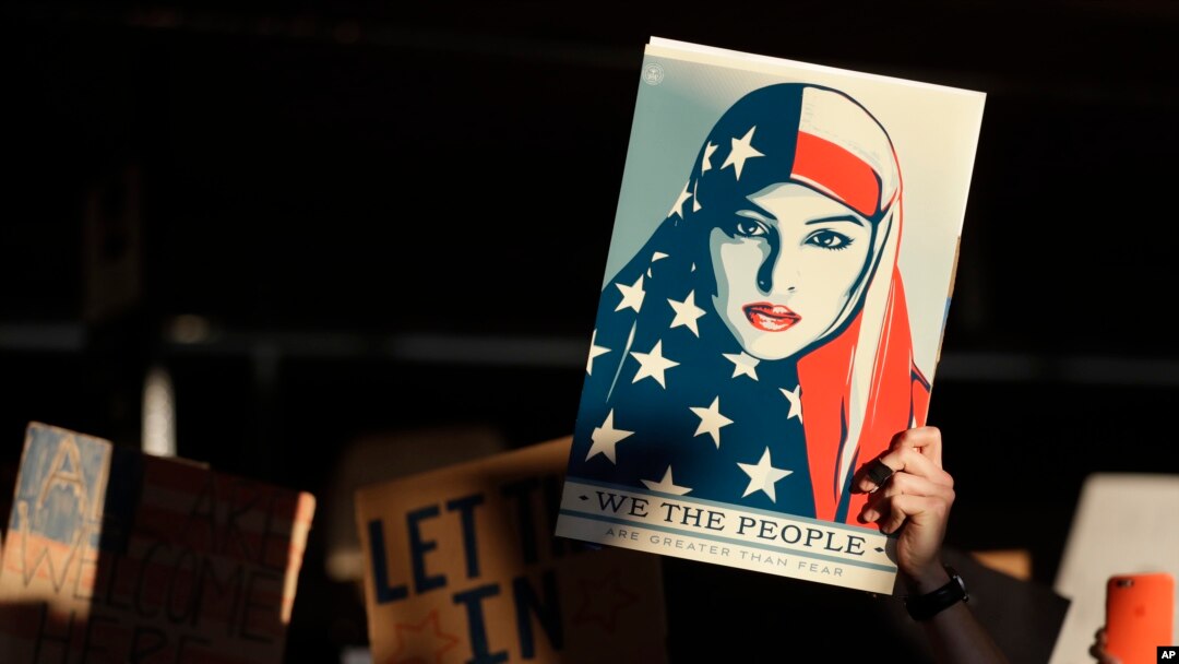 FILE - A protester holds a sign at San Francisco International Airport during a demonstration to denounce President Donald Trump's executive order that bars citizens of seven predominantly Muslim-majority countries from entering the U.S., Jan. 28, 2017.
