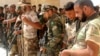 Newly arrived Iraqi Shi'ite militiamen check their weapons in the predominately Sunni city of Nukhayb, in southwest Iraq, May 21, 2015. Many analysts predict deep sectarian divisions will cripple the fight against the Islamic State group.
