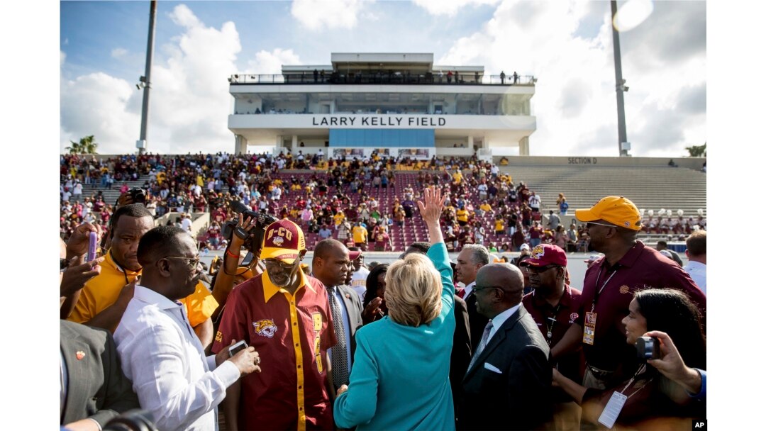 Democratic presidential candidate Hillary Clinton waves while visiting a homecoming game for Bethune-Cookman University Wildcats in Daytona Beach, Fla., Oct. 29, 2016, on her way to a rally.