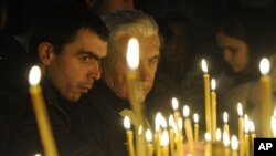 FILE - People light candles in a church to mark the Orthodox Christmas in the Kyiv-Pechersk Lavra church in Kiev, Ukraine, Jan. 6, 2012.