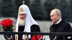 Патріарх РПЦ Кирил та президент Росії Володимир Путін на Красній площі в Москві. 4 листопада 2018 року. "Російський уряд у царському стилі, разом із його головною силою, РПЦ-МП, є прототипом державного контролю та гноблення, а релігійні громади є полем битви", – звіт ICC. (AP) 