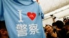 2019年8月13日在香港国际机场抗议的示威者从身穿黑色T恤衫的环球网记者付国豪（中）的背包里找出一件印有“我爱香港警察”图样的T恤衫。