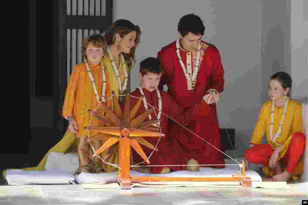 Canadian Prime Minister Justin Trudeau&#39;s son Xavier tries his hands on a spinning wheel as his mother, Sophie Gregoire Trudeau, father Justin Trudeau, brother Hadrien, left, and sister Ella-Grace watch him during their visit to Sabarmati Ashram or Mahatma Gandhi Ashram in Ahmadabad, India.