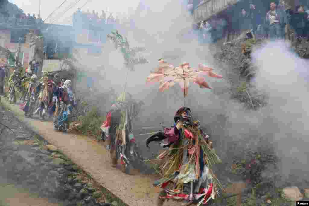 Villagers dressed up as local mountain gods walk around to give good wishes during a celebration event for Chinese Lunar New Year in a Miao village in Liuzhou, Guangxi Zhuang Autonomous Region, China, Feb. 18, 2018.