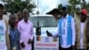 Humanitarian workers stand in front of convoy to transport CAR refugees back home, in Garoua Boulai, Cameroon, Oct. 23, 2019. (Moki Edwin Kindzeka/VOA)