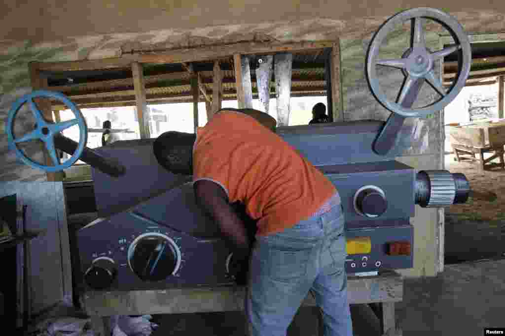 An employee works on a coffin in the shape of a film projector in the workshop of Kane Kwei in the Teshi area of Accra, Ghana, May 16, 2013.