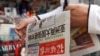 一个中国人拿着《环球时报》，2010年。(资料图)