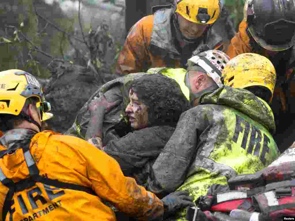 Emergency personnel carry a woman rescued from a collapsed house after a mudslide in Montecito, California, Jan. 9, 2018.
