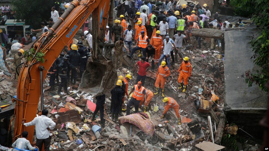 Rescuers sift through debris after a five-story building collapsed in the Ghatkopar area of Mumbai, India, July 25, 2017.