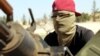 A masked member of Libyan internationally recognized pro-government forces is seen in a military vehicle on the outskirts of Tripoli, Libya, April 10, 2019.