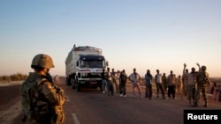 French soldiers search people at a checkpoint on the outskirts of Gao, Mali, February 14, 2013. 