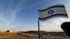 FILE - An Israeli flag stands by a road near the Israeli settlement of Shlomtzion in the Jordan valley of the occupied West Bank, Jan. 27, 2020.
