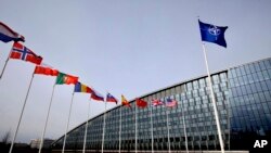 Прапори майорять біля штаб-квартири НАТО в Брюсселі, 28 лютого 2020 року. (Фото: AP Photo/Olivier Matthys, File)
