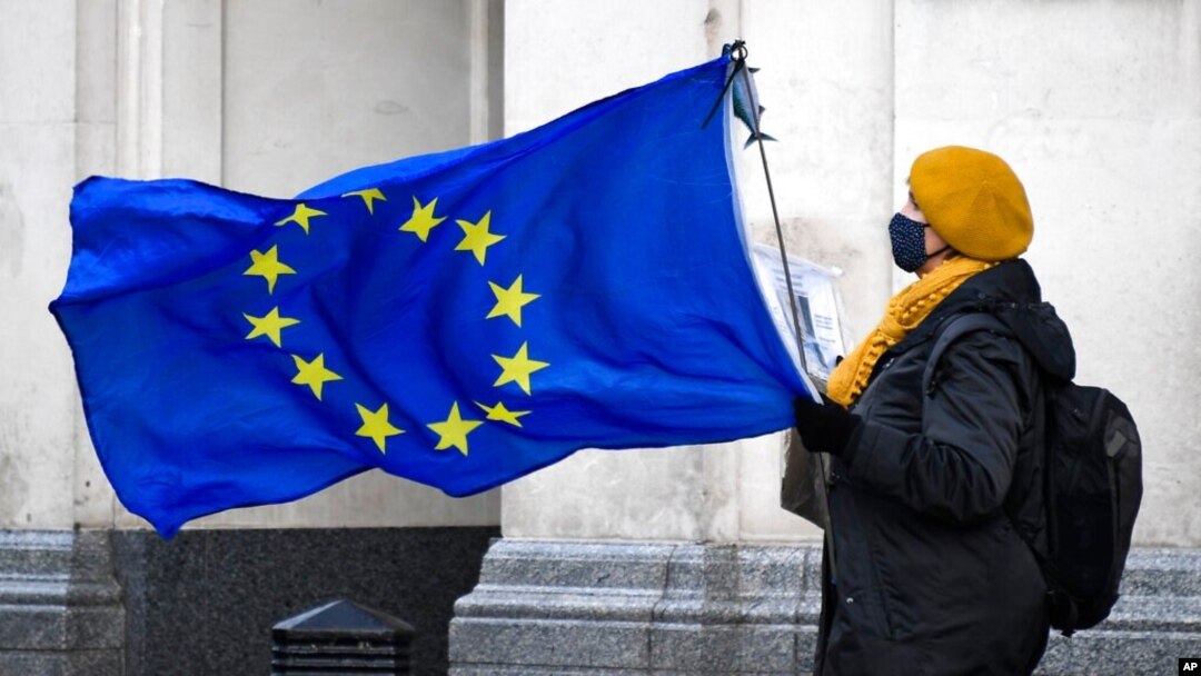 An anti-Brexit demonstrator holds an EU flag in Parliament Square, in London, Dec. 16, 2020.