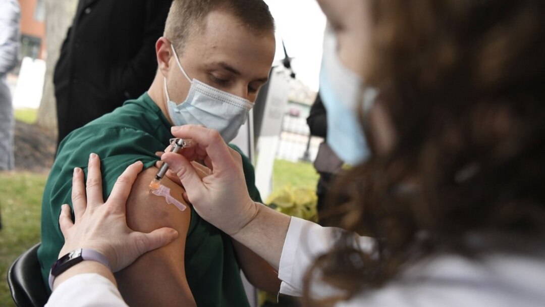 Colleen Teevan, System Pharmacy Clinical Manager at Hartford HealthCare, administers the Pfizer-BioNTech vaccine for COVID-19 to healthcare worker Connor Paleski outside of Hartford Hospital, Monday, Dec. 14, 2020, in Hartford, Conn. (AP Photo/Jessica Hil