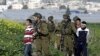 Israeli soldiers arrest Palestinian youths during a protest north of the West Bank city of Jenin in support to the Palestinian prisoners, Feb. 22, 2013. 