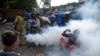 FILE - People react as a civic worker fumigates a slum area as a preventive measure against malaria and dengue ahead of monsoon in Mumbai, India, June 12, 2020.