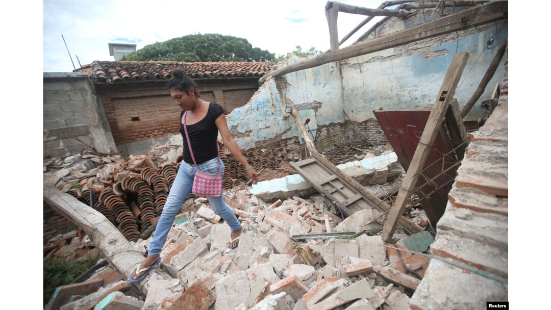 Una indígena zapoteca Muxe camina sobre los escombros de su casa destruida por el terremoto que estremeció la costa sur de México el jueves 7 de septiembre. Juchitán, Mexico, Sept. 10, 2017.