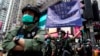 资料照片：香港警方在庆祝中国共产党建立中华人民共和国的节日期间在铜锣湾街向抗议者举出警告旗帜。(2020年10月1日)