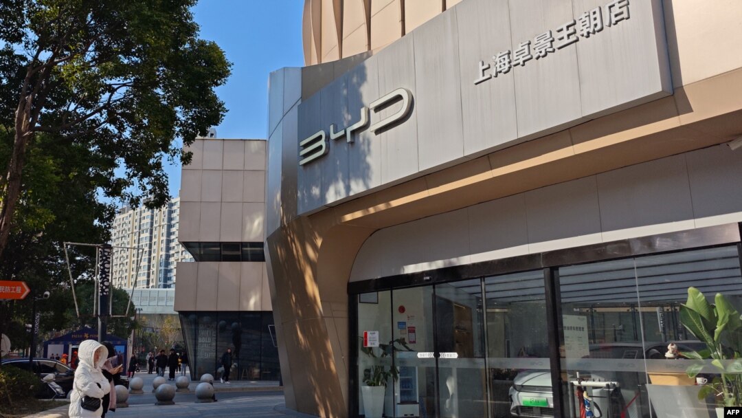 People stand outside an auto shop of the Chinese electric vehicle manufacturer BYD Co. Ltd. in east China's Shanghai on Dec. 27, 2024. A contractor for BYD denied on Dec. 26 there were 'slave-like conditions' in a Brazil factory, 