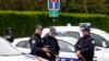 French police officers block the road leading to a crime scene the day after a knife-wielding attacker stabbed a senior police officer to death Monday evening outside his home in Magnanville, west of Paris, June 14, 2016. 