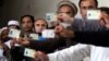 Afghan men display their identification cards as the wait to cast their votes outside a polling station in Kabul, Afghanistan, Saturday, June 14, 2014.